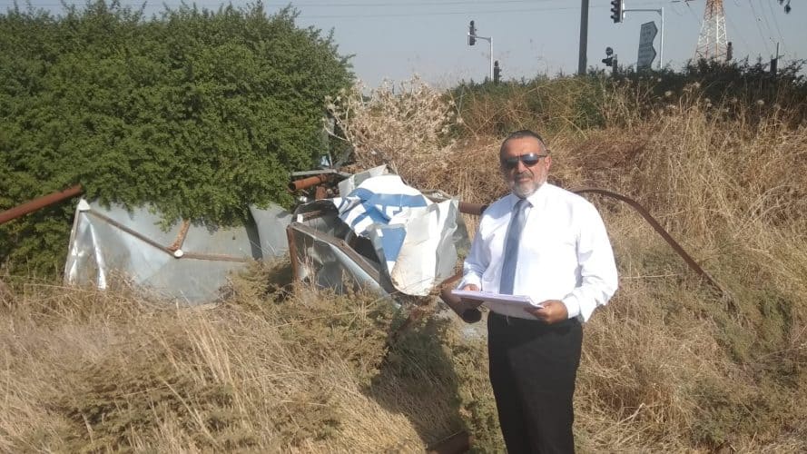 עוזי אהרון ליד השלט של בית הקברות