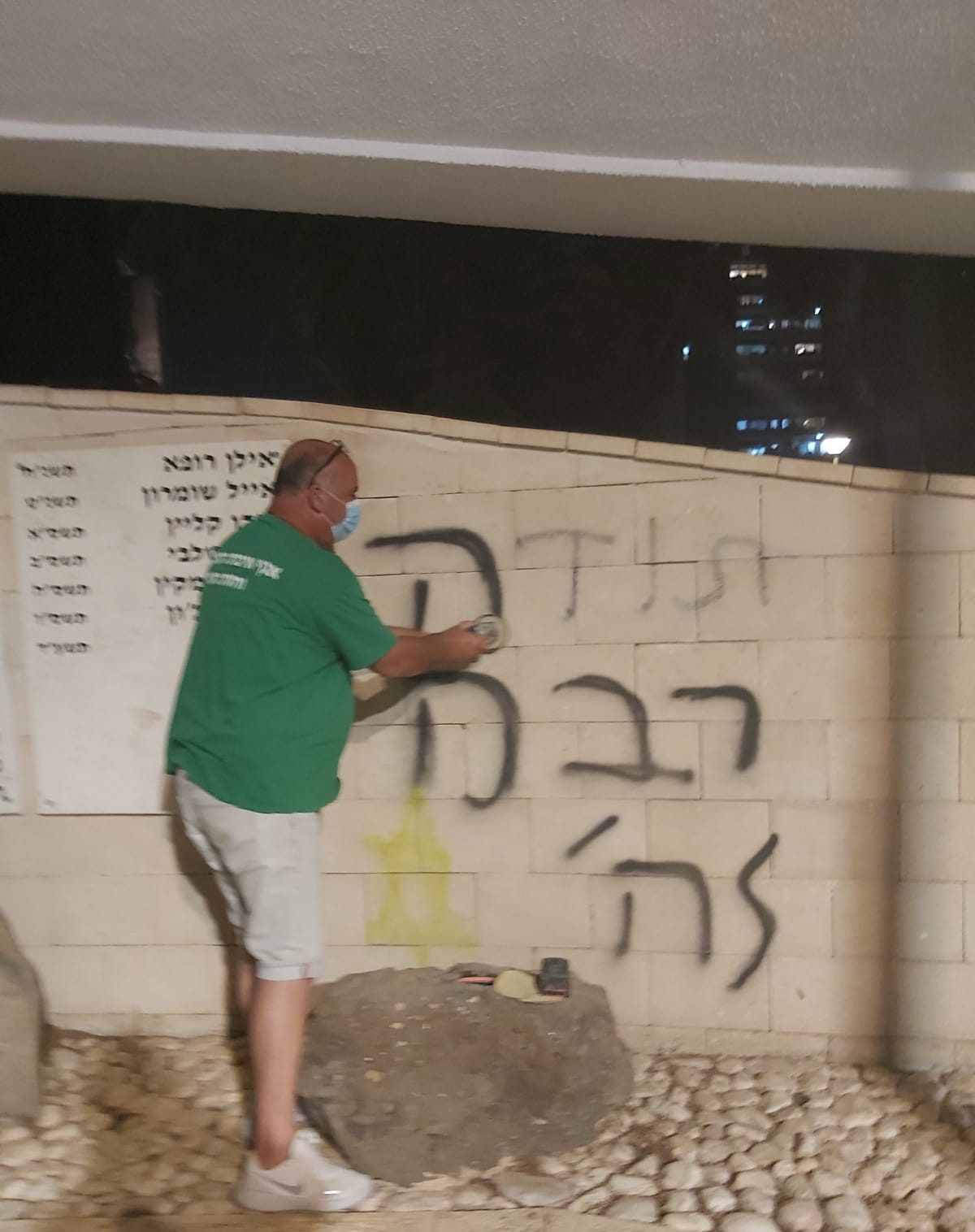 עובד עיריית יהוד-מונוסון מנקה את כתובת הגרפיטי שרוססה על האנדרטה לזכר חללי יהוד. צילום: דוברות עיריית יהוד-מונוסון