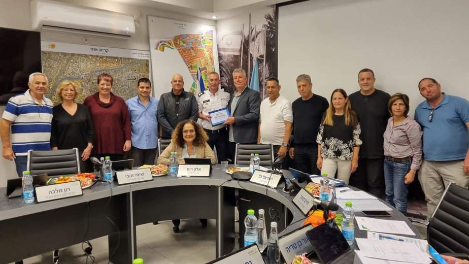 ישראל גל, ראש העיר קריית אונו, מעניק מגן הוקרה לניר שלהב (במדי מד"א) יחד עם חברי מועצת העיר, והוריו של ניר (משמאל). צילום עיריית קריית אונו